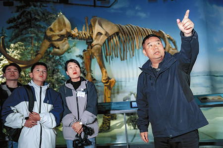 郭进(右一)在澄江化石地世界自然遗产博物馆为观众讲解生命演化知识。_副本