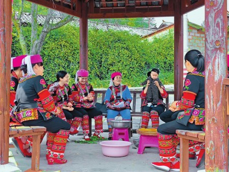 熊文兰(中)向乡亲们宣讲两会精神。