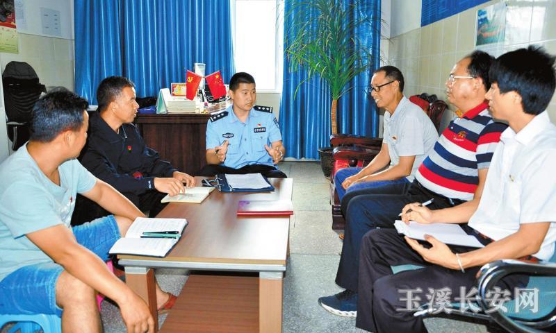 戛洒派出所社区民警黄永付与社区干部研究日常工作 陈猛 摄